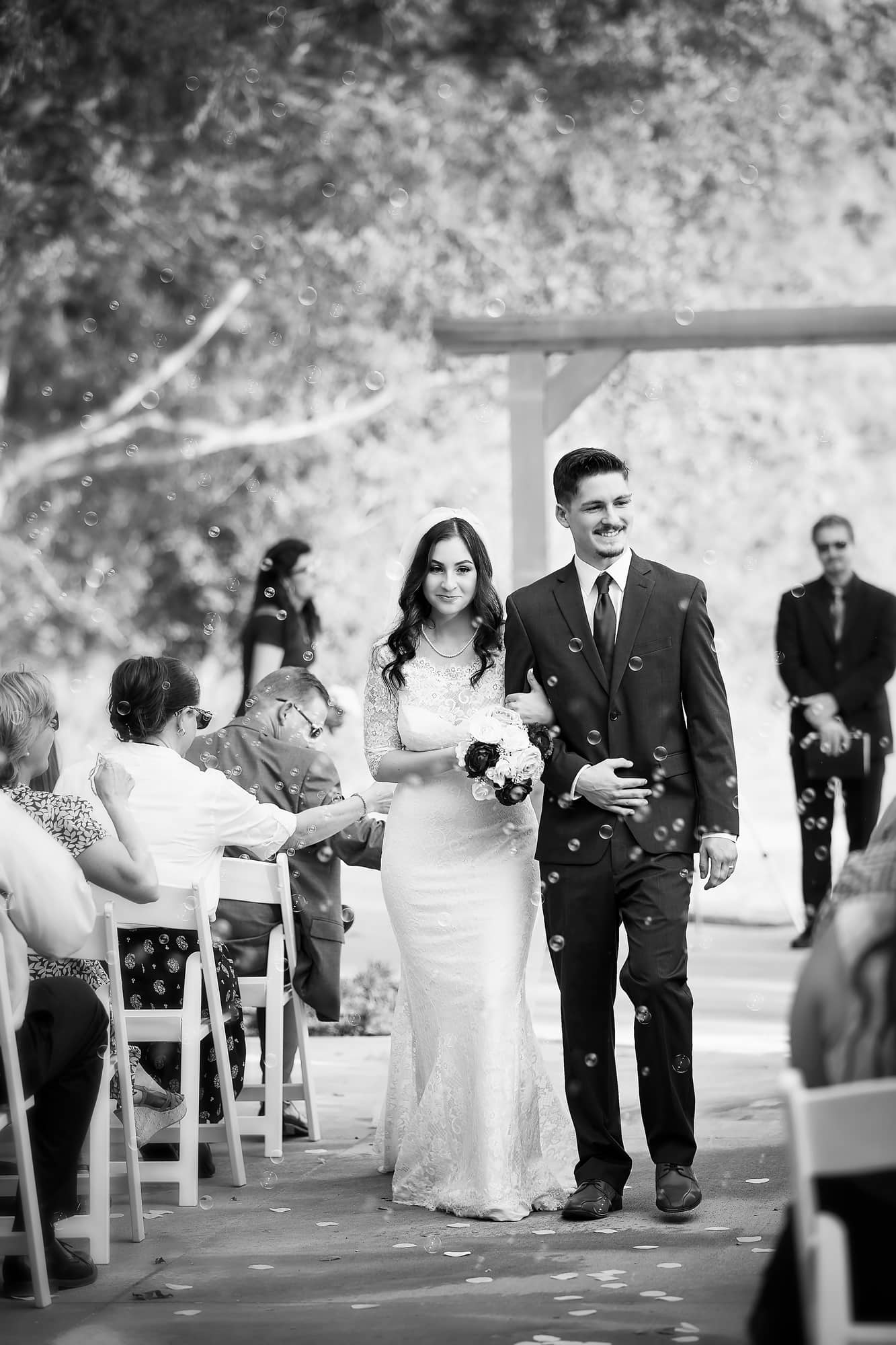 bride and groom walking down aisle in black and white